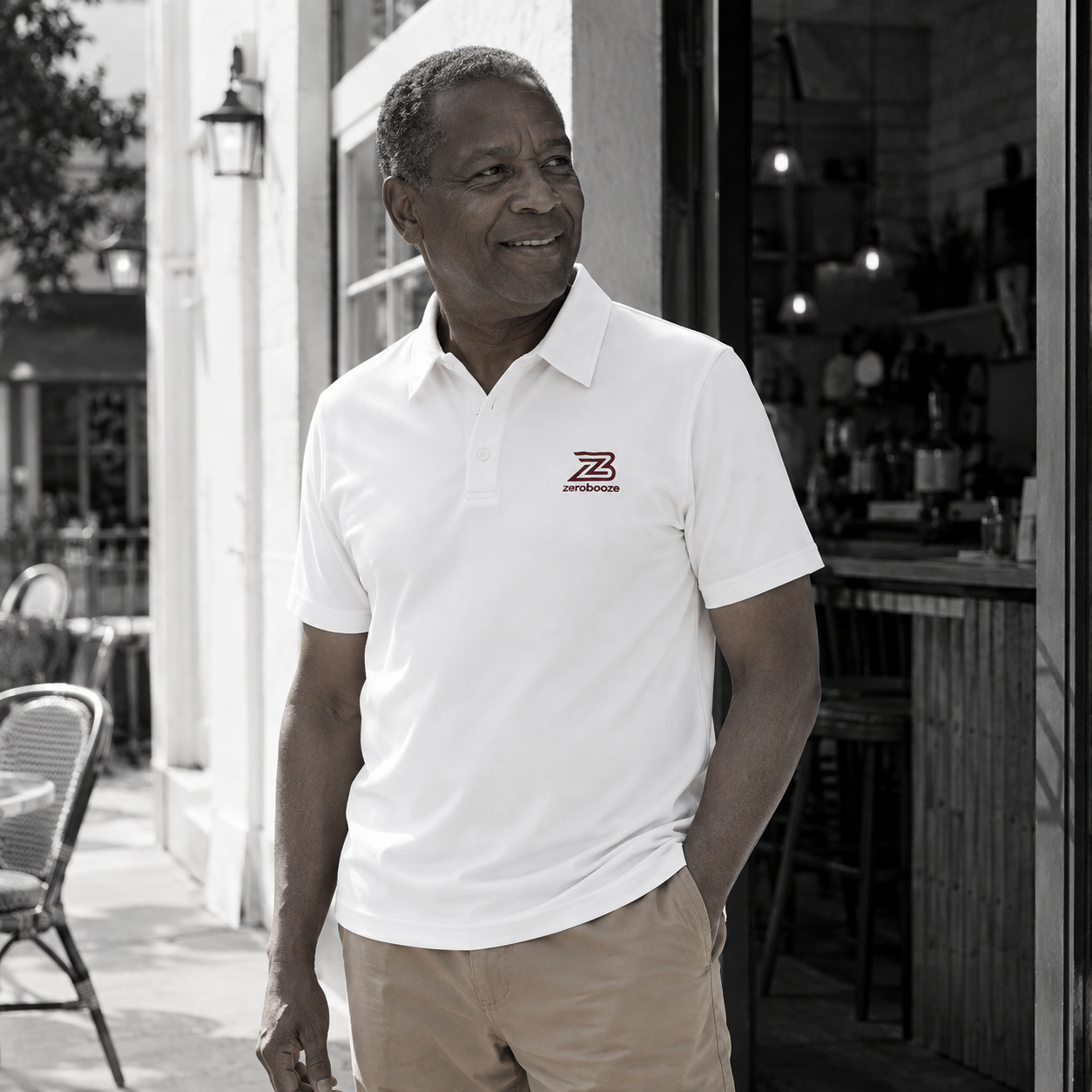 Man wearing the white Zero Booze polo outside a café