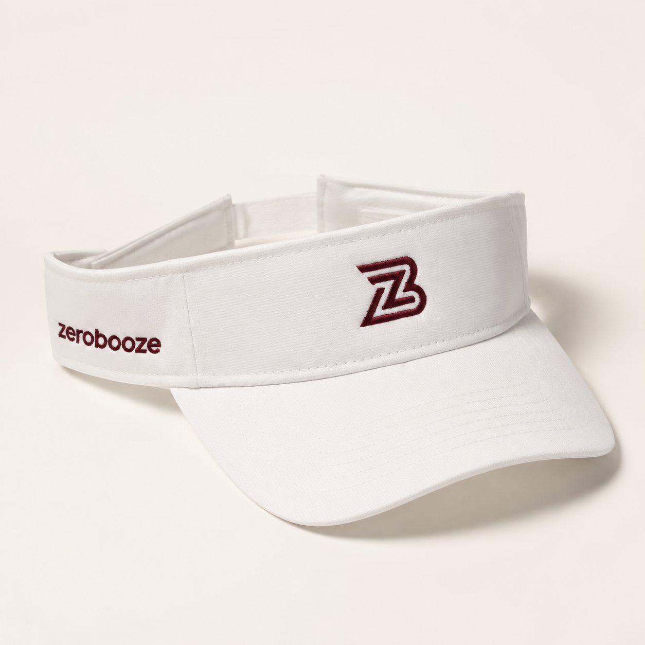 White Zero Booze visor with burgundy ZB embroidery on a warm-white background